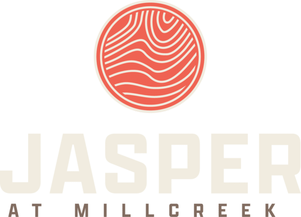Logo for Jasper at Mill Creek: circular orange-red motif above the cream wordmark 'JASPER' with 'AT MILL CREEK' subtitle.